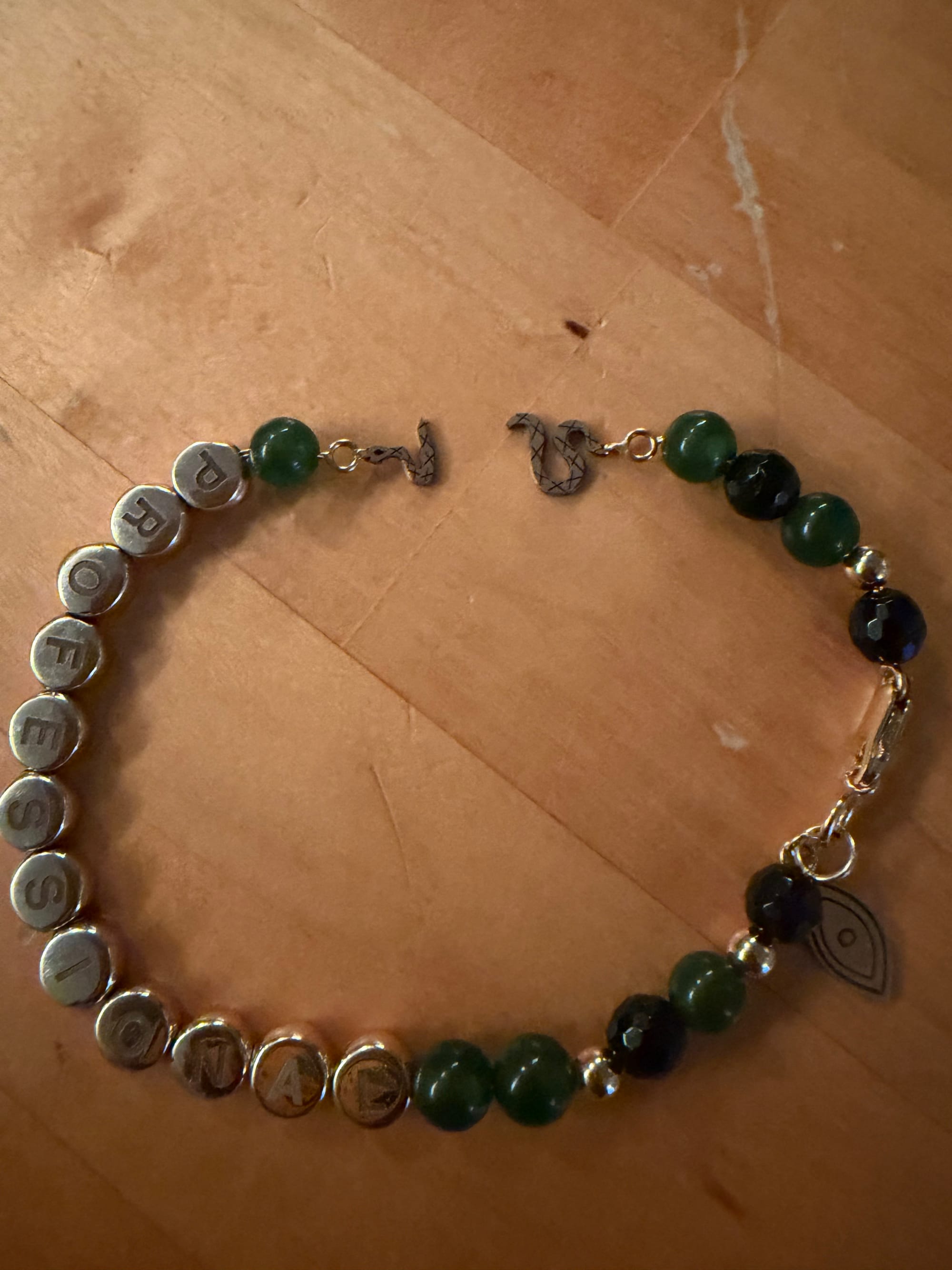 A top down photo of the PROFESSIONAL bracelet. The snake is broken in the middle of its body.