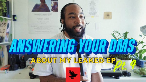 Paul is wearing a white t-shirt, and holding a microphone. His hair is braided. The title graphic for Answering Your DMs is set in front of him.