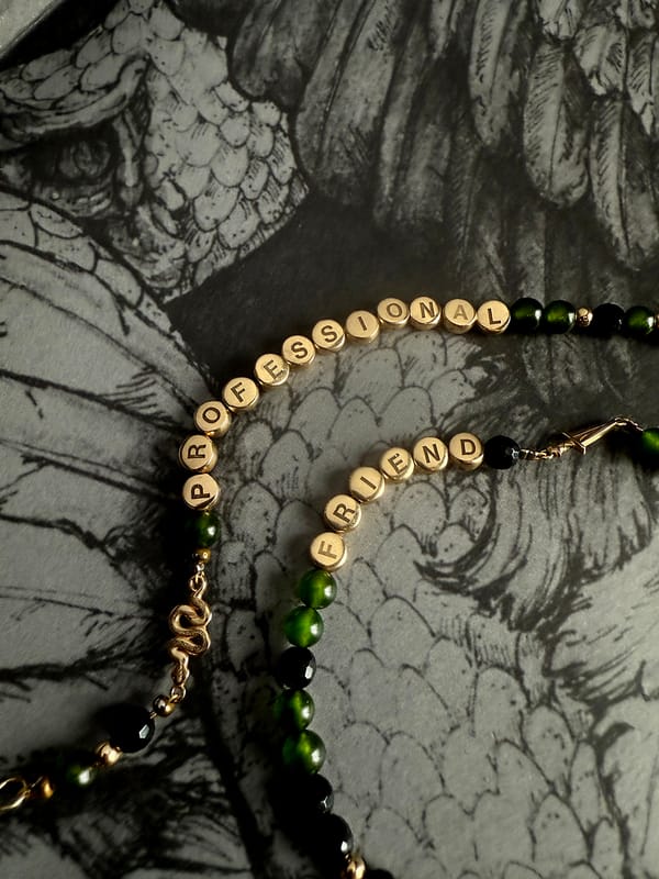 Close up photo of the un-friendship bracelets, set against an ornately illustrated bookplate.